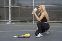 Girl drinking from Splitflask while at a Pickle ball court